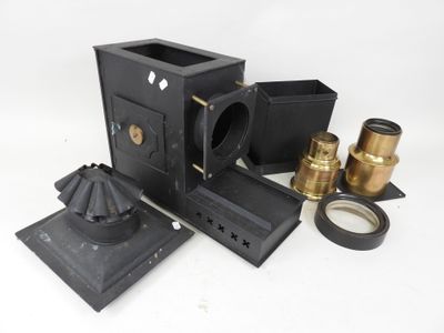 a black camera and some other items on a white surface
