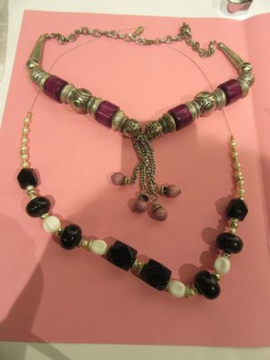 purple and black beaded necklace and bracelet set on a pink background