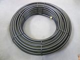 a close up of a coil of black hose sitting on a floor