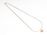 an image of a necklace with two small charms on it
