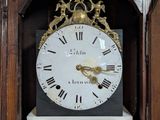 a wooden grandfather clock with roman numerals on the face