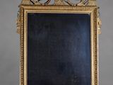 un miroir orné d'un cadre doré, avec un tableau noir au centre