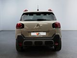 the rear end of a beige citrole parked in a white room