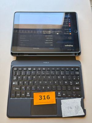 two laptops sitting on a table with a price tag on the keyboard
