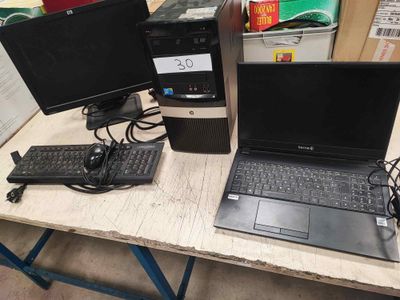 a laptop computer sitting on a desk next to a monitor and keyboard