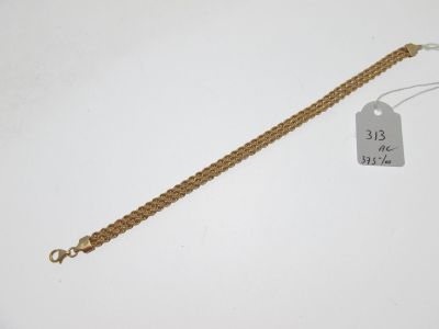 une photo d'un bracelet en or auquel est attachée une étiquette
