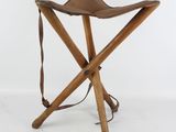 stool made of wood and leather with a strap around the seat