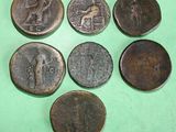 six different types of ancient coins on a green surface