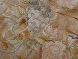 a close up of a bed with a floral design on it