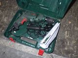 une mallette verte posée par terre, contenant des outils