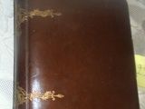 un livre marron posé sur une table, sur lequel est collé un autocollant jaune