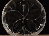 a glass plate with a flower inside of it on a table