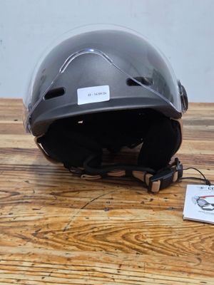 a helmet sitting on a wooden table with a tag attached to it