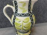 a green and white vase sitting on a table