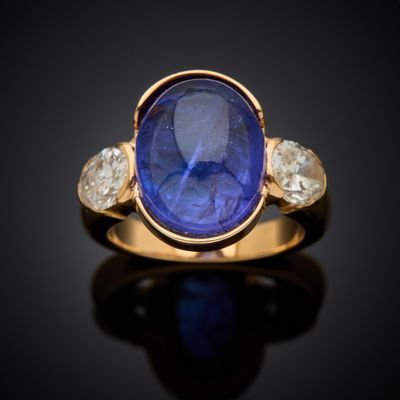 a gold ring with a blue sapphire and three white diamonds