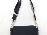 the small black bag is hanging on the wall with a black strap