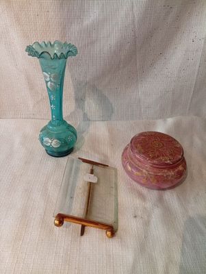 un vase bleu et une boîte rose posés sur un tissu blanc