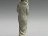 a white figurine of a woman with a hat on her head
