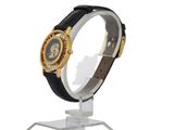 a black and gold watch on a stand on a white background