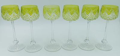 six verres à vin jaunes alignés sur une surface blanche