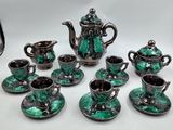 several pieces of green and black tea set on a white table