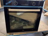 a black oven sitting on a cart in a warehouse