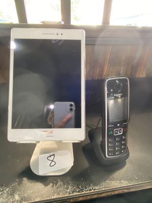 two cell phones sitting on a table next to a cell phone