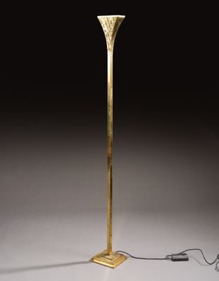 a tall brass floor lamp with a white shade on top of it