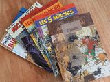several children ' s books sitting on a wooden table with a cat