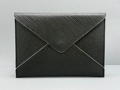 Une enveloppe noire est posée sur une table blanche.
