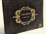 an old black book with gold writing on it sitting on a white surface