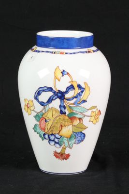a white vase with a blue ribbon and flowers on it