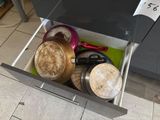 a drawer full of pots and pans in a kitchen