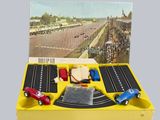une boîte jaune contenant des petites voitures et sur laquelle figure l'image d'un circuit automobile