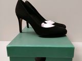 black and white high heel shoes on a green box on a white surface