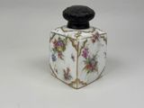 a small white box with a black lid and flowers on it