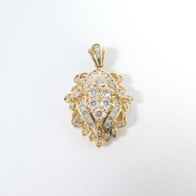 un gros plan d'un pendentif en or et diamants sur fond blanc