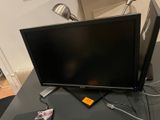 a flat screen tv sitting on top of a desk next to a laptop