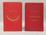 two red books sitting side by side on a white surface