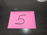 un gros plan sur un morceau de papier rose sur lequel figure le chiffre 5