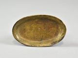 an image of a small bronze plate on a white surface