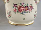 a white bowl with flowers on it sitting on a table