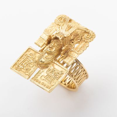 an image of a gold ring with a statue on it