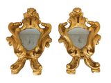 une paire de miroirs dorés avec un cadre doré et un miroir orné d'un oiseau