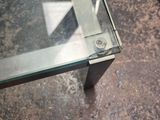 a glass table with a metal base and a glass top