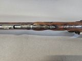 a wooden pen with a metal handle on a white surface