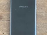 un gros plan d'un samsung s10 noir sur une table en bois