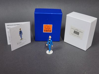 une petite figurine représentant un homme debout à côté d'une cabine téléphonique bleue