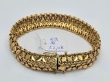 a gold bracelet on a white background with a price tag