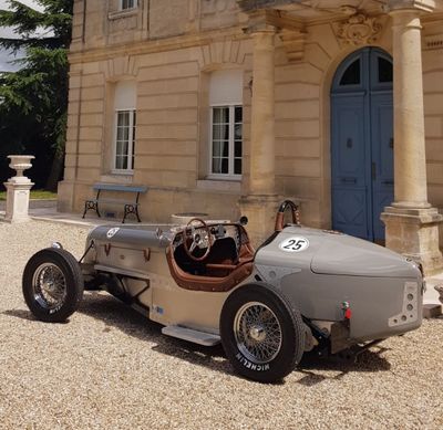 une voiture ancienne garée devant un grand immeuble